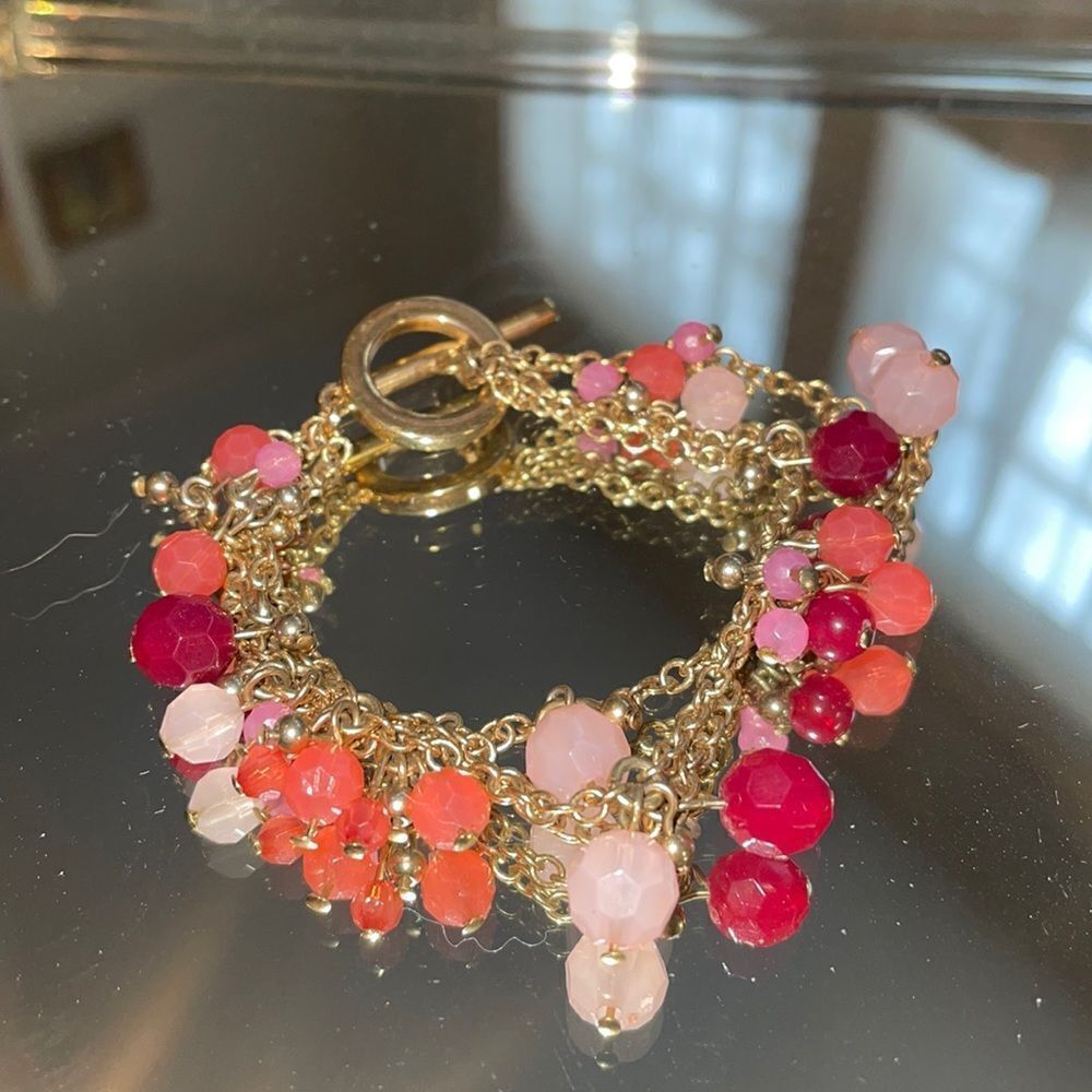 Gold tone triple layer chain bracelet with pink & maroon plastic beads
